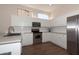 Modern kitchen with stainless steel appliances, white cabinets, and dark wood floors at 17441 W Rock Ledge Rd, Goodyear, AZ 85338