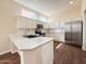 Bright kitchen featuring white cabinets, a subway tile backsplash, stainless appliances, and a center island at 17441 W Rock Ledge Rd, Goodyear, AZ 85338