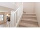 Carpeted staircase leads to the upper level with views of the well-lit open floor plan at 17441 W Rock Ledge Rd, Goodyear, AZ 85338