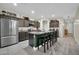 Spacious kitchen featuring a large center island with seating, stainless steel appliances, and granite countertops at 17634 W Via De Luna Dr, Surprise, AZ 85387