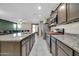 Open kitchen with large center island, modern appliances, granite countertops, and views into the living room at 17634 W Via De Luna Dr, Surprise, AZ 85387