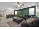 Comfortable living room features a large sectional sofa, ceiling fan, and an accent wall at 17634 W Via De Luna Dr, Surprise, AZ 85387