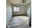 Well-lit bedroom with wood flooring, neutral paint, and a large window with bright light at 18391 W Stinson Dr, Surprise, AZ 85374