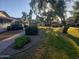 Well-maintained front yard with lush green grass, mature trees, and manicured landscaping at 18841 N Palomar Dr, Sun City West, AZ 85375