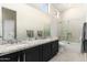 A bathroom with double sinks, granite counters, and a glass-enclosed shower and tub at 19460 N 84Th St, Scottsdale, AZ 85255