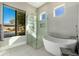 Modern bathroom with natural light featuring a stand-alone tub and a glass-enclosed shower at 19460 N 84Th St, Scottsdale, AZ 85255