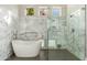 Modern bathroom with white marble accents, a stand-alone tub, and a glass-enclosed shower at 19460 N 84Th St, Scottsdale, AZ 85255