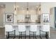 Beautiful kitchen island featuring white countertops, white cabinets, stylish lighting and seating for four at 19460 N 84Th St, Scottsdale, AZ 85255