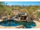 A rock waterfall feature creates a peaceful oasis in the pool with mountain views beyond at 19460 N 84Th St, Scottsdale, AZ 85255