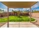 Covered patio overlooking a backyard with a grassy area, gravel, and a stucco fence at 20914 N 39Th Way, Phoenix, AZ 85050