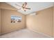 Cozy bedroom with a ceiling fan, carpet, and a window overlooking the neighborhood at 20914 N 39Th Way, Phoenix, AZ 85050