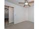 Standard bedroom featuring neutral carpet, a ceiling fan, and an entrance to a bathroom at 21511 N 79Th Dr, Peoria, AZ 85382