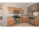 Well-lit kitchen featuring stainless steel appliances, tile backsplash and warm wood cabinets at 21511 N 79Th Dr, Peoria, AZ 85382