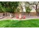 Backyard sitting area with seating arranged around an outdoor fireplace feature at 21732 N 86Th Ln, Peoria, AZ 85382