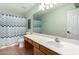 Bathroom boasts a long counter with a sink, toilet, and shower with chevron curtain at 21732 N 86Th Ln, Peoria, AZ 85382