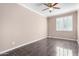 Bedroom features tile floors, a ceiling fan, and a large window for natural light at 21732 N 86Th Ln, Peoria, AZ 85382