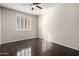 Bright bedroom features a ceiling fan, window with shutters, and shiny tile flooring at 21732 N 86Th Ln, Peoria, AZ 85382