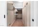 Long, narrow walk-in closet featuring multiple shelves and rods for storage at 21732 N 86Th Ln, Peoria, AZ 85382