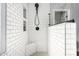 Shower stall featuring white subway tile, built-in bench, and modern shower head at 21732 N 86Th Ln, Peoria, AZ 85382