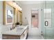 Bright bathroom features double vanity with gold fixtures and a glass-enclosed shower at 21824 N 32Nd Ave, Phoenix, AZ 85027