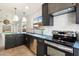 Well-lit kitchen featuring stainless steel appliances, dark cabinets, light backsplash, and modern pendant lighting at 21824 N 32Nd Ave, Phoenix, AZ 85027