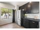 Kitchen with stainless steel refrigerator, dark cabinets, light backsplash, and a window view at 21824 N 32Nd Ave, Phoenix, AZ 85027