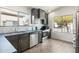 Bright kitchen featuring stainless steel appliances, dark cabinets, light backsplash, and a large window at 21824 N 32Nd Ave, Phoenix, AZ 85027