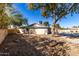 Backyard view with desert landscaping and mature tree providing shade on a sunny day at 2201 S Evergreen Rd, Tempe, AZ 85282