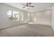 Spacious living room with neutral carpet, ceiling fan, and a window letting in natural light at 2201 S Evergreen Rd, Tempe, AZ 85282