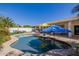 Inviting pool area with umbrellas, ample seating, and a fire pit for outdoor enjoyment at 24416 S Lakestar Dr, Sun Lakes, AZ 85248