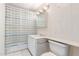 Bathroom with a bathtub and shower, white cabinets and toilet and a striped shower curtain at 2806 W Marshall Ave, Phoenix, AZ 85017