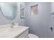 Bathroom features a white vanity, a round mirror, and blue painted walls at 2806 W Marshall Ave, Phoenix, AZ 85017