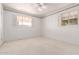 Bright bedroom with white walls, neutral carpet, a ceiling fan, and two windows at 2806 W Marshall Ave, Phoenix, AZ 85017