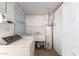 Functional laundry room featuring a utility sink, washer, dryer, water heater, and storage at 2806 W Marshall Ave, Phoenix, AZ 85017