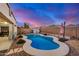 Stunning backyard pool featuring a rock waterfall and vibrant landscaping at 29983 W Fairmount Ave, Buckeye, AZ 85396