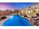 Gorgeous backyard pool featuring lush greenery, patio spaces, and a rock feature at 29983 W Fairmount Ave, Buckeye, AZ 85396