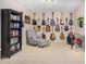 Cozy room with many guitars on the wall and comfy chair with bookcase at 29983 W Fairmount Ave, Buckeye, AZ 85396