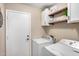 Functional laundry room with washer, dryer, shelving, and ample storage space at 29983 W Fairmount Ave, Buckeye, AZ 85396