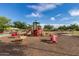 Full playground area featuring a wooden play structure, spring animal riders, and a swing set for to enjoy at 29983 W Fairmount Ave, Buckeye, AZ 85396