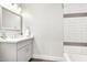 Bright bathroom featuring modern fixtures, quartz counters, and tiled shower with stylish accent stripes at 3007 N 47Th St, Phoenix, AZ 85018