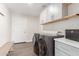 Well-lit laundry room with modern appliances, white cabinets, and gray quartz countertops at 3007 N 47Th St, Phoenix, AZ 85018