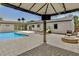 Backyard featuring a sparkling pool, fire pit, lounge seating, and a covered patio, perfect for entertaining at 3007 N 47Th St, Phoenix, AZ 85018