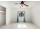A simple bedroom with white tile flooring, a ceiling fan, a closet and window at 3042 N 87Th Ave, Phoenix, AZ 85037