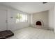 Bright living room featuring tiled floors, a brick fireplace, and ample natural light at 3042 N 87Th Ave, Phoenix, AZ 85037
