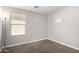 This empty room features neutral walls, wood floors, a window, and recessed lighting at 306 W Angus Rd, San Tan Valley, AZ 85143