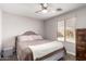 This cozy bedroom features a ceiling fan, neutral walls, wood floors, and a window at 306 W Angus Rd, San Tan Valley, AZ 85143