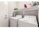 Bright laundry room featuring white washer and dryer, convenient upper shelf, and a clean, functional design at 306 W Angus Rd, San Tan Valley, AZ 85143