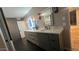 Modern bathroom with dual sinks, dark gray cabinets, and tile floors at 30600 N Pima Rd # 19, Scottsdale, AZ 85266