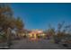 Home exterior featuring desert landscaping, stucco walls, and an illuminated entry at night at 30600 N Pima Rd # 19, Scottsdale, AZ 85266