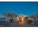 Beautiful home exterior features desert landscaping, a paver driveway, and warm lighting at dusk at 30600 N Pima Rd # 19, Scottsdale, AZ 85266